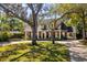 Beautiful brick home with mature trees, circular driveway, and a welcoming front porch; a classic and elegant residence at 1911 Stonehurst Rd, Winter Park, FL 32789