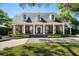 Stunning brick home with a charming front porch, featuring white columns, black shutters, and inviting curb appeal at 1911 Stonehurst Rd, Winter Park, FL 32789