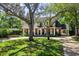 Charming traditional home with a manicured lawn, mature trees, and a welcoming front porch with columns at 1911 Stonehurst Rd, Winter Park, FL 32789