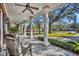 Inviting front porch boasts classic columns, slate tile flooring, and a cozy seating area overlooking the landscaped yard at 1911 Stonehurst Rd, Winter Park, FL 32789