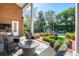 Relaxing patio area with wicker furniture, a fire pit, lush green landscaping, and view of the pool area at 1911 Stonehurst Rd, Winter Park, FL 32789