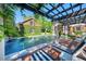Inviting pool and spa area with a pergola, lounge chairs, and a red brick and black tile design at 1911 Stonehurst Rd, Winter Park, FL 32789