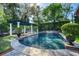 Stunning pool area with blue waters, a pergola, and lush landscaping creating a serene backyard oasis at 1911 Stonehurst Rd, Winter Park, FL 32789