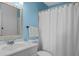 Bathroom showcasing bright blue walls, framed mirror, and white shower curtain at 2046 Ambergris Dr, Orlando, FL 32822