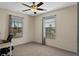 Cozy bedroom featuring neutral tones, two windows, and a ceiling fan at 2046 Ambergris Dr, Orlando, FL 32822