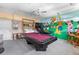 This unique game room features a pool table, Disney mural, ceiling fan and fun for everyone at 2248 Wyndham Palms Way, Kissimmee, FL 34747