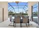 Covered outdoor patio area with a dining set and view of the pool at 2248 Wyndham Palms Way, Kissimmee, FL 34747