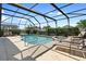 A sparkling screened-in pool and spa are surrounded by lounge chairs, offering a perfect blend of relaxation and recreation at 2248 Wyndham Palms Way, Kissimmee, FL 34747