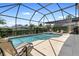 A screened-in pool offers a private outdoor oasis with lounge chairs for relaxation and lush green landscaping at 2248 Wyndham Palms Way, Kissimmee, FL 34747