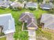 Bird's eye view of a home with manicured landscaping, a brick driveway, and a well-maintained roof, in a green neighborhood at 253 Lake Cassidy Dr, Kissimmee, FL 34759