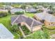 Aerial shot of a house with a landscaped yard, brick driveway, and a tidy roof in a lush, green residential area at 253 Lake Cassidy Dr, Kissimmee, FL 34759