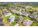 Scenic aerial view of a community with manicured lawns, mature trees, and varied residential architecture, close to a golf course at 253 Lake Cassidy Dr, Kissimmee, FL 34759