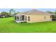 Exterior of a home with a screened patio and expansive lawn at 253 Lake Cassidy Dr, Kissimmee, FL 34759