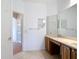 Bathroom with a marble countertop vanity and a large mirror with decorative lighting at 253 Lake Cassidy Dr, Kissimmee, FL 34759