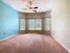 Spacious bedroom with neutral walls, large windows, ceiling fan, and light brown carpet at 253 Lake Cassidy Dr, Kissimmee, FL 34759