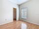 Bright bedroom featuring wood flooring, window, closet, and neutral walls at 253 Lake Cassidy Dr, Kissimmee, FL 34759