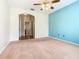 Bedroom featuring light brown carpet, ceiling fan, and doorway leading to en-suite bathroom at 253 Lake Cassidy Dr, Kissimmee, FL 34759