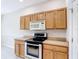 Kitchen featuring tile flooring, stainless steel appliances, and light wood cabinetry at 253 Lake Cassidy Dr, Kissimmee, FL 34759
