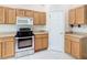 Well-equipped kitchen with a stainless steel oven, microwave, and wood cabinets at 253 Lake Cassidy Dr, Kissimmee, FL 34759