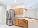 Kitchen with stainless steel refrigerator and light wood cabinets at 253 Lake Cassidy Dr, Kissimmee, FL 34759