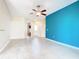 Bright living room featuring tile flooring, a ceiling fan, and a striking accent wall at 253 Lake Cassidy Dr, Kissimmee, FL 34759