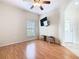 Bright living room with wood laminate flooring, ceiling fan, and a wall mounted television at 253 Lake Cassidy Dr, Kissimmee, FL 34759