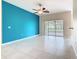 Living room with tile flooring, a vibrant blue accent wall, and sliding glass doors at 253 Lake Cassidy Dr, Kissimmee, FL 34759