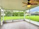 Enclosed patio with tiled flooring, ceiling fan, and screen windows overlooking the landscaped backyard at 253 Lake Cassidy Dr, Kissimmee, FL 34759
