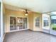 Covered patio features tiled flooring, ceiling fan, and a sliding glass door to the home's interior at 253 Lake Cassidy Dr, Kissimmee, FL 34759