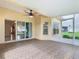 This is an airy screened-in patio with ceiling fan and a view into the home at 253 Lake Cassidy Dr, Kissimmee, FL 34759