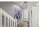 Hallway with decorative Disney welcome mural and wood-look floors leading to the front door at 2537 Renshaw St, Kissimmee, FL 34747