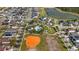 Aerial view showcases a community pool, baseball field, playground, and pond nestled amongst homes and green spaces at 3242 Irish Peach Dr, Winter Garden, FL 34787