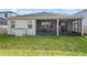 Home's backyard featuring a screened-in patio, large grassy area, and convenient outdoor storage unit at 3242 Irish Peach Dr, Winter Garden, FL 34787