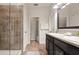 Well-lit bathroom with double vanity, walk-in shower, and wood-look tile flooring at 3242 Irish Peach Dr, Winter Garden, FL 34787