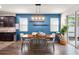 Dining area with a vibrant blue accent wall, modern light fixture and access to the kitchen at 3242 Irish Peach Dr, Winter Garden, FL 34787