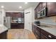 Modern kitchen featuring dark cabinetry, stainless steel appliances, and wood-look tile flooring at 3242 Irish Peach Dr, Winter Garden, FL 34787