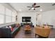 Cozy living room featuring a ceiling fan, media center, leather sofa and comfortable seating, perfect for relaxing at 3242 Irish Peach Dr, Winter Garden, FL 34787