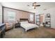 Serene main bedroom featuring a decorative brick wall, ceiling fan, and a sliding barn door leading to the bathroom at 3242 Irish Peach Dr, Winter Garden, FL 34787