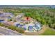 Aerial view of a residential neighborhood with mature landscaping and green spaces surrounded by trees and roadways at 368 Sand Ridge Dr, Davenport, FL 33896