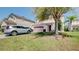 Two-story home with a well-manicured lawn, mature tree, and driveway with vehicles in a residential area at 368 Sand Ridge Dr, Davenport, FL 33896