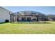 Wide shot of the screened in backyard pool with a large lawn at 368 Sand Ridge Dr, Davenport, FL 33896