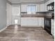 Bright kitchen with white cabinets, stainless steel sink, and wood-look flooring at 3764 Pinehurst St, Deltona, FL 32738