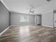 Bright living room featuring gray walls, laminate floors, a modern ceiling fan, and a large window at 3764 Pinehurst St, Deltona, FL 32738