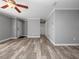 Expansive living room showcasing neutral gray walls, wood-look floors, and a ceiling fan at 3764 Pinehurst St, Deltona, FL 32738