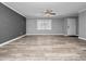 Open-concept living room with neutral gray walls, modern ceiling fan, and stylish wood-look flooring at 3764 Pinehurst St, Deltona, FL 32738