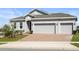 Lovely view of a single-Gathering home featuring a brick driveway and a two-car garage at 417 Ironside Trail Dr, Groveland, FL 34736