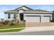 Daytime exterior view of a single-Gathering home with a brick driveway and a well-manicured lawn at 417 Ironside Trail Dr, Groveland, FL 34736