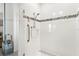 Modern shower with white tile, mosaic accent stripe, and glass door at 417 Ironside Trail Dr, Groveland, FL 34736