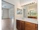 Elegant bathroom vanity featuring wood cabinets, light countertop, and large mirror at 4724 Sable Ridge Ct, Leesburg, FL 34748