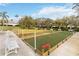 Bocce ball court with wooden benches for seating is surrounded by manicured green landscape and mature trees at 4724 Sable Ridge Ct, Leesburg, FL 34748